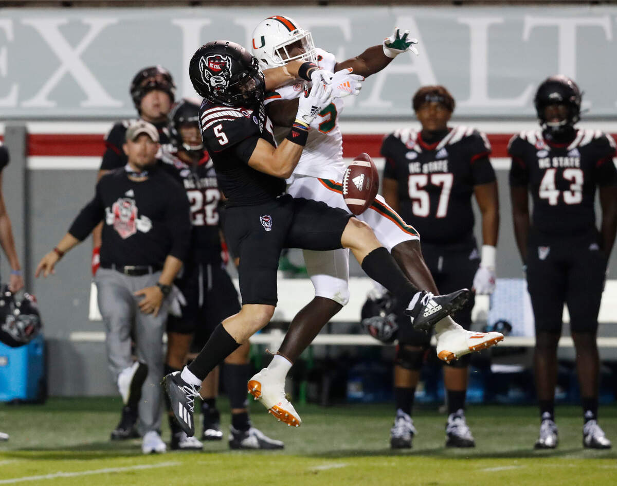 Miami safety Amari Carter (5) breaks up a pass intended for N.C. State wide receiver Thayer Thomas (5) during the first half of N.C. State’s game against Miami at Carter-Finley Stadium in Raleigh, N.C., Friday, Nov. 6, 2020.