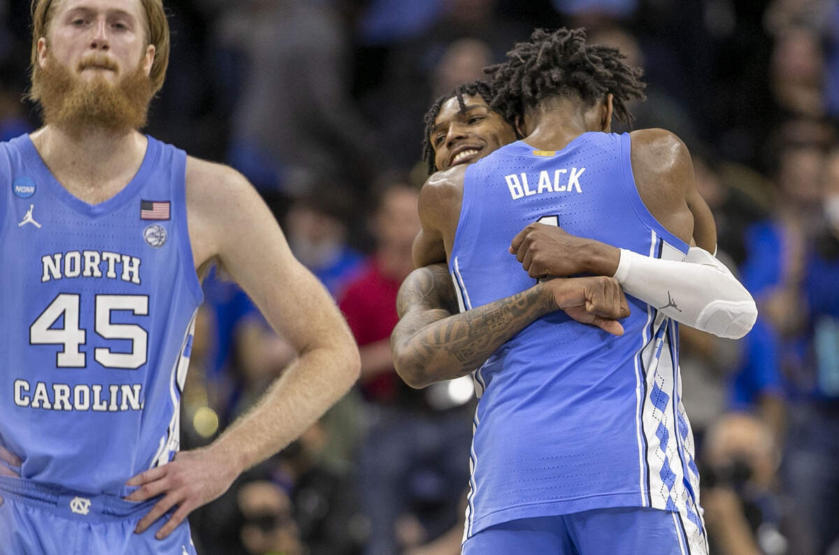 North Carolina’s Caleb Love (2) embraces Leaky Black (1) as teammate R.J. Davis (4) shoots the final two free throws with no time on the clock to secure the Tar Heels’ 73-66 victory over UCLA on Friday, March 25, 2022 during the NCAA East Regional semi-final at Wells Fargo Center in Philadelphia, Pa. Love lead the Tar Heels’ with 30 points.