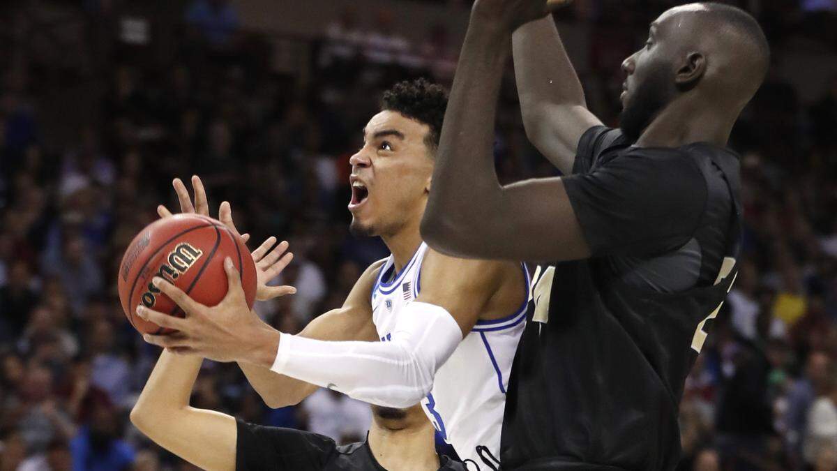 Duke’s Tre Jones (3) drives to the basket past UCF’s Tacko Fall (24) during the first half of Duke’s game against UCF in the second round of the NCAA Men’s Basketball Championship in Columbia, S.C., Sunday, March 24, 2019.