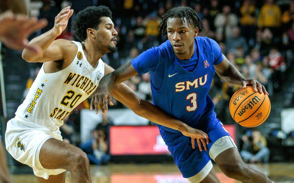 Southern Methodist Mustangs guard Chuck Harris (3) drives around Wichita State Shockers guard Harlond Beverly (20) during their game at Charles Koch Arena in January 2024.