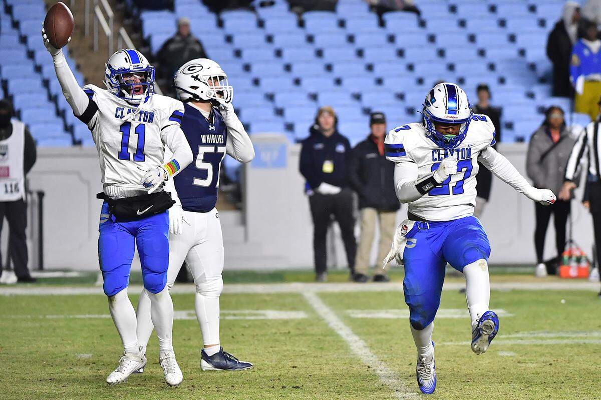 Clayton defensive lineman Kaden Blackwell (27) and linebacker Christian Schmidt (11) react after the sack of Grimsley quarterback Faizon Brandon during the first half.  The Clayton Comets and the Grimsley Whirlies met in the NCHSAA 7A football Championships in Chapel Hill, NC on December 12, 2025.