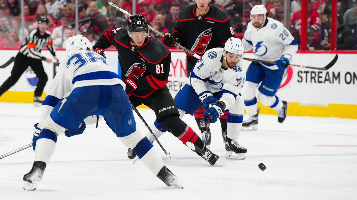Oct 11, 2024; Raleigh, North Carolina, USA; Carolina Hurricanes center Jesperi Kotkaniemi (82) is back checked by Tampa Bay Lightning center Anthony Cirelli (71) during the third period at Lenovo Center. Mandatory Credit: James Guillory-Imagn Images