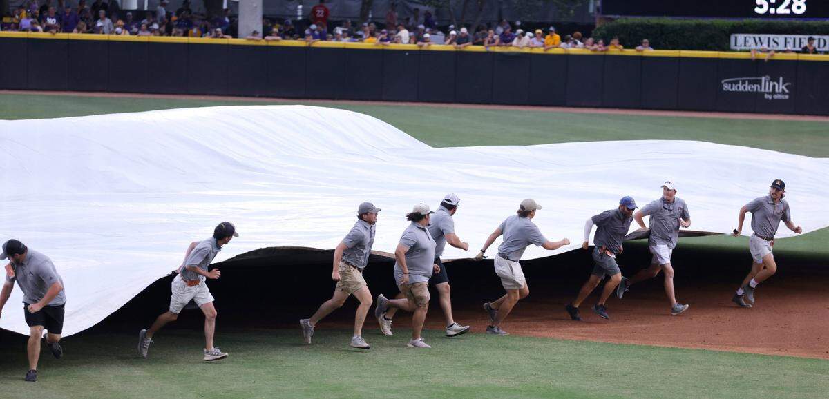 The grounds crew brings out the tarp during a weather delay in the first inning during ECUs game against Texas in the Greenville Super Regional at Clark-LeClair Stadium Sunday, June 12, 2022.