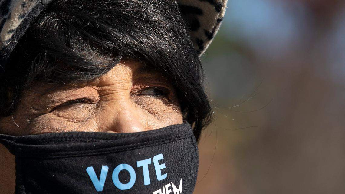 Marge Clemons wears a mask encouraging people to vote while standing outside the Durham County Main Library on Tuesday, Nov. 8, 2022, in Durham, N.C.
