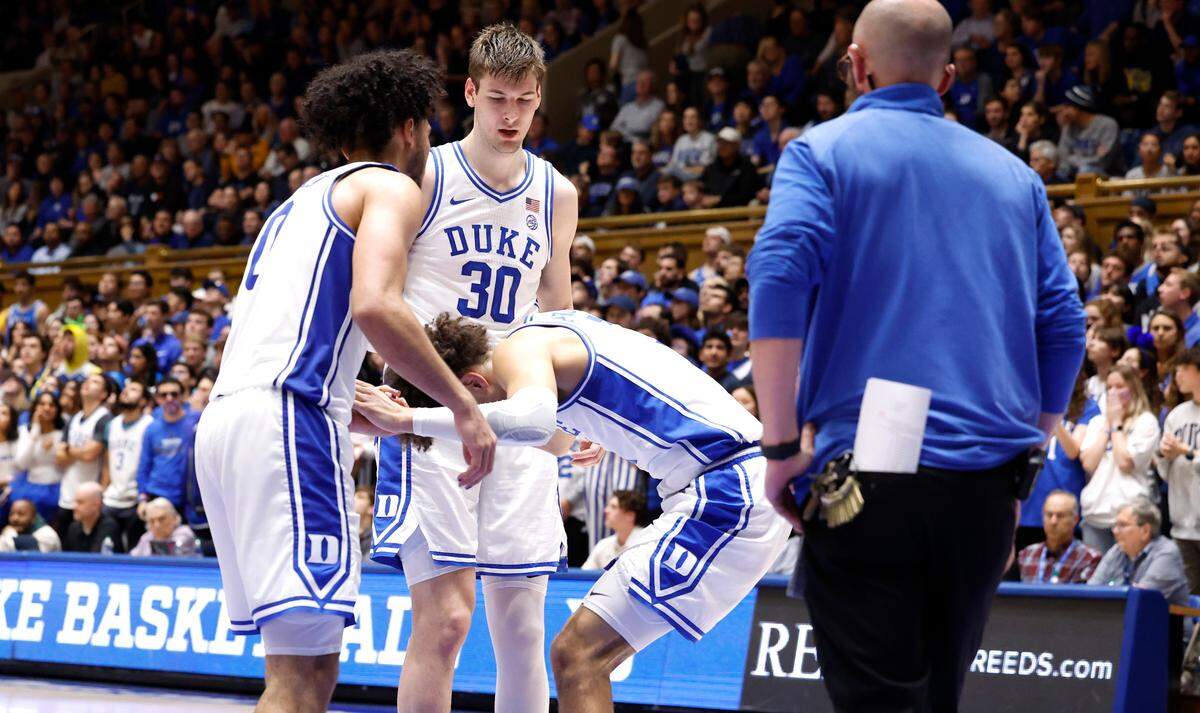 Duke’s Jared McCain (0) and Duke’s Kyle Filipowski (30) helps Duke’s Tyrese Proctor (5) up after he was injured during the first half of Duke’s game against Wake Forest at Cameron Indoor Stadium in Durham, N.C., Monday, Feb. 12, 2024.