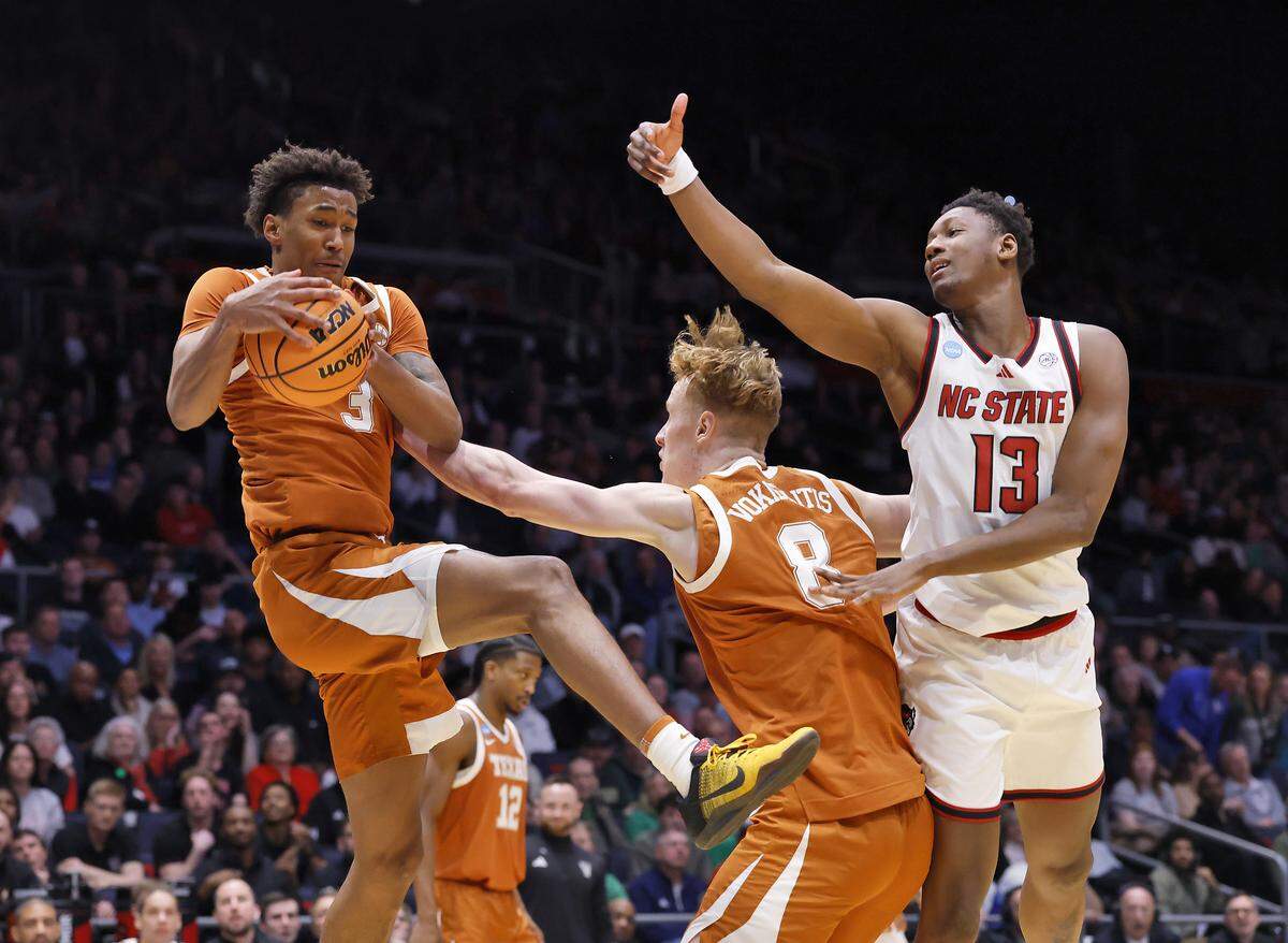 Texas’ Dailyn Swain (3) pulls down a rebound away from N.C. State’s Musa Sagnia during the second half of the Wolfpack’s 68-66 loss in the NCAA First Four on Tuesday, March 17, 2026, at the University of Dayton Arena in Dayton, Ohio. 