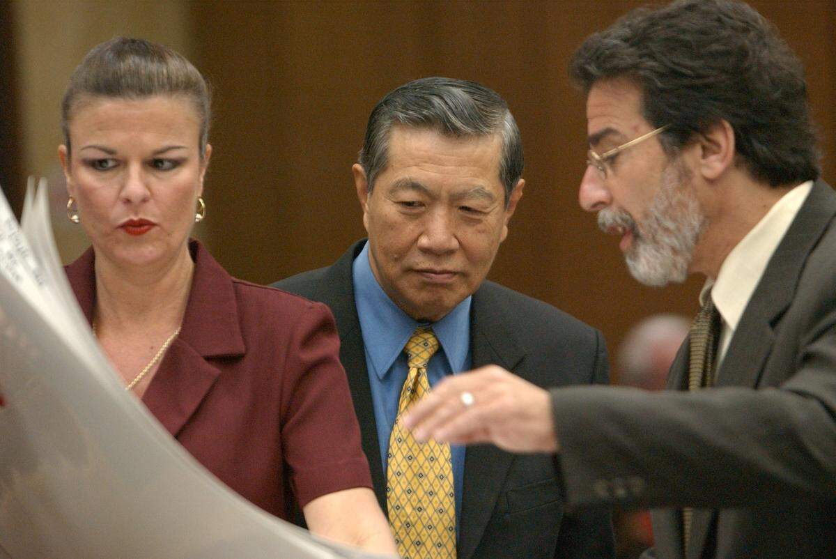 Henry C. Lee, prominent forensic scientist, center, looks over the shoulders of Durham prosecutor Freda Black, left, and defense attorney David Rudolf, right, Monday noontime as Rudolf borrowed some of the state's evidence in the 46th day of the Michael Peterson murder trial.