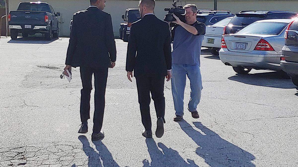 State Rep. Cody Henson, R-Transylvania, center, exits the Transylvania County Courthouse in Brevard after a first appearance on a cyberstalking charge Thursday, as WLOS reporter Justin Hinton, left, and camera operator Todd Robbins attempt to interview him.