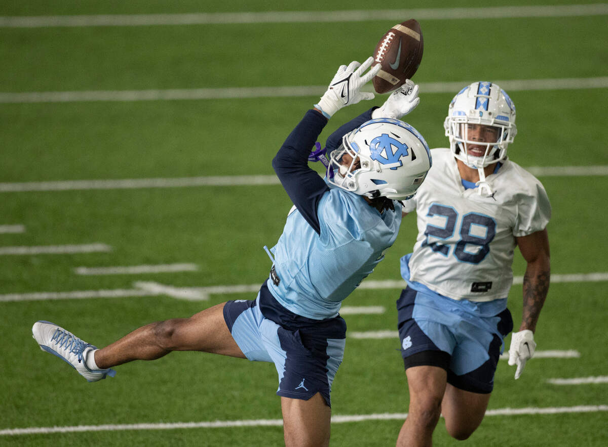 North Carolina wide receiver Christian Hamilton (7) bobbles a pass reception allowing defensive back Alijah Huzzie (28) to intercept the ball during the opening day of spring football practice on Tuesday, March 19, 2024 in Chapel Hill, N.C.
