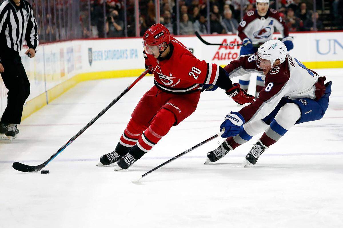 Carolina Hurricanes’ Sebastian Aho (20) controls the puck in front of Colorado Avalanche’s Cale Makar (8) during the second period of an NHL hockey game in Raleigh, N.C., Thursday, March 10, 2022. (AP Photo/Karl B DeBlaker)