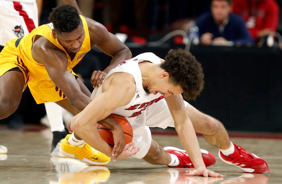 N.C. State’s Jericole Hellems (4) takes the ball from Bethune-Cookman’s Damani McEntire (5) during the first half of N.C. State’s game against Bethune-Cookman University at Reynolds Coliseum in Raleigh, N.C., Thursday, December 9, 2021.