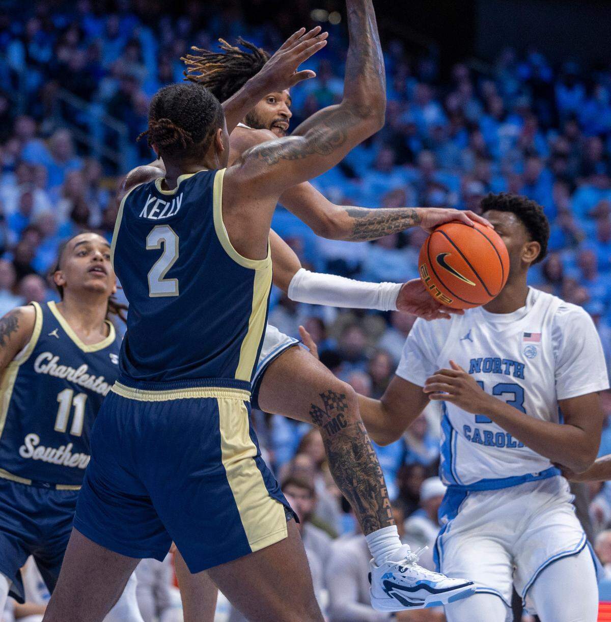 North Carolina’s R.J. Davis (4) passes the ball around Charleston Southern’s Taje Kelly (2) for an assist to Jalen Washington in the second half on Friday, December 29, 2023 at the Smith Center in Chapel Hill, N.C. Davis led the Tar Heels with 20 points and 10 assists.