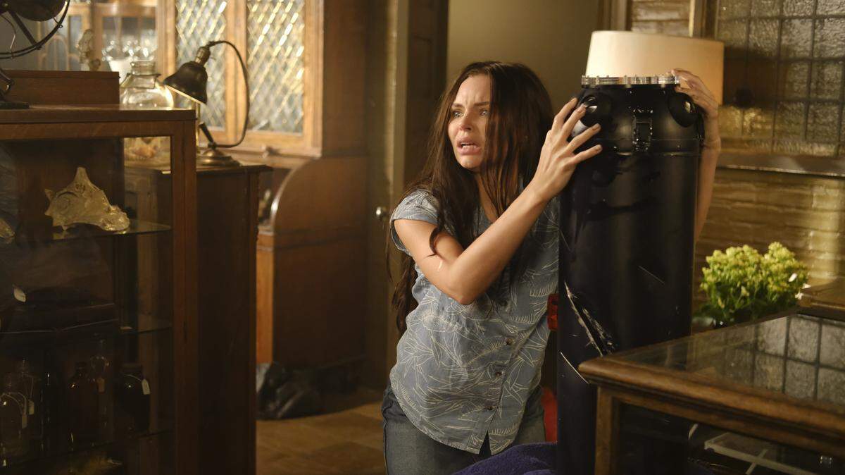 Ryn (Eline Powell) finds shelter in the home of a local folklore expert, and encounters a device emitting a strange sound.