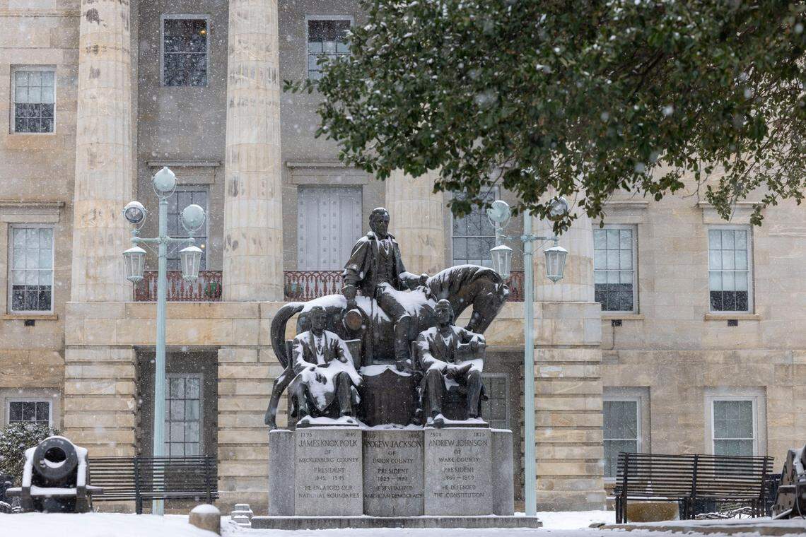 A light snow falls over the State Capitol grounds, dusting the North Carolina Presidents monument on Thursday afternoon February 20, 2025 in Raleigh, N.C.