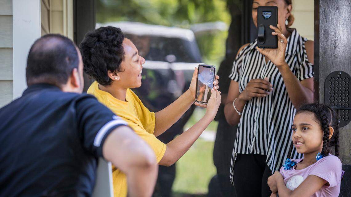 Kayasia Palomino holds a phone so her brother Kollin, a graduating senior at Knightdale High School, can wave through a FaceTime call to principal Keith Richardson, left, while his mom Kimberly takes a video and his sister Kayla looks on in excitement. Richardson and other faculty from the school drove all over Knightdale, N.C. on Monday, May 4, 2020 to deliver signs to the homes of all graduating seniors and to send them well wishes as graduation details remain uncertain due to coronavirus restrictions.