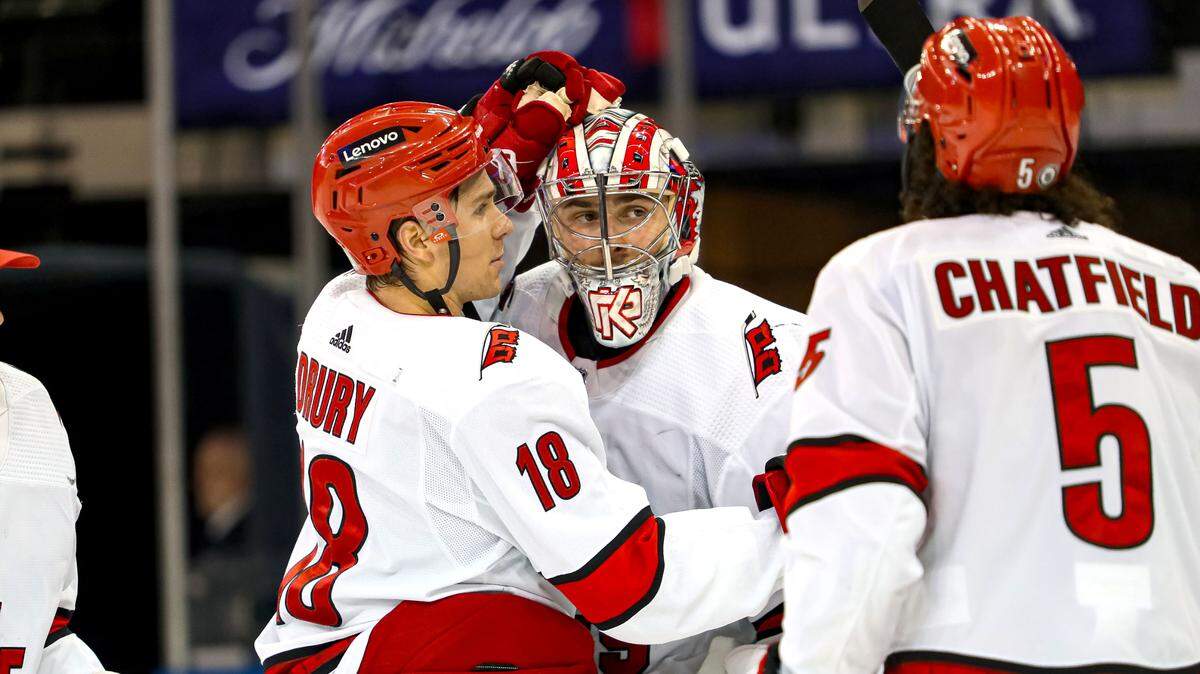 Jan 2, 2024; New York, New York, USA; Carolina Hurricanes goalie Pyotr Kochetkov (52) celebrates a 6-1 win against the New York Rangers with center Jack Drury (18) and defenseman Jalen Chatfield (5) at Madison Square Garden. Mandatory Credit: Danny Wild-USA TODAY Sports