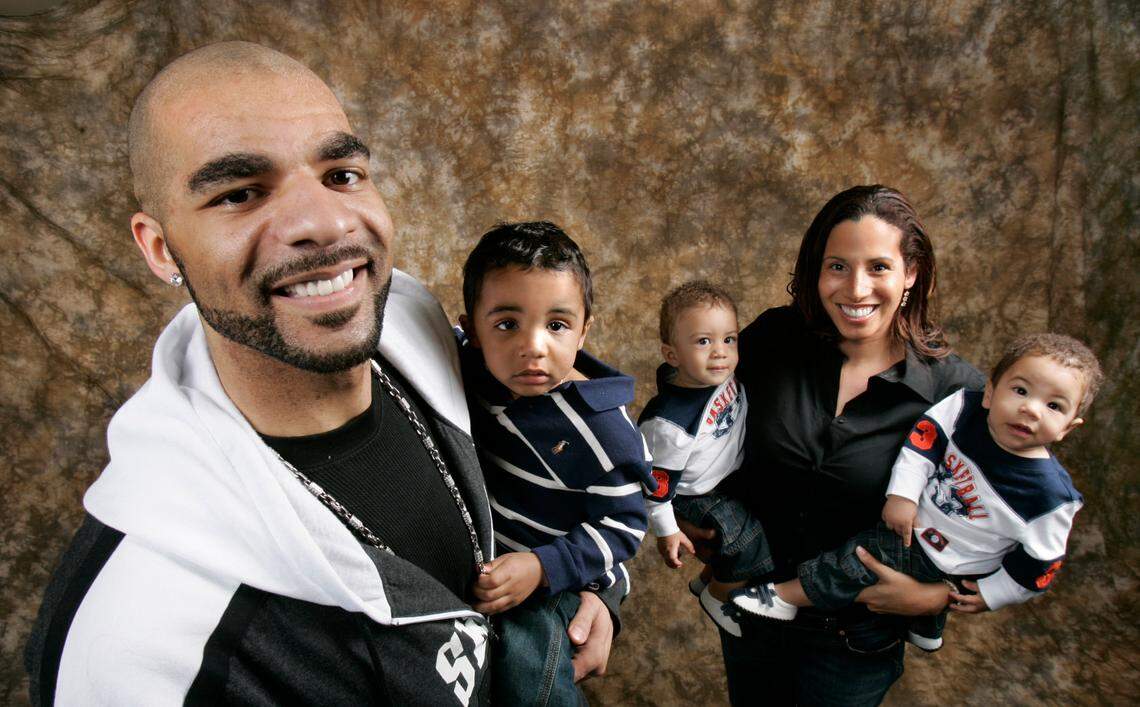 In this 2008 file photo, Utah Jazz basketball player Carlos Boozer poses with his son Carmani as his wife CeCe holds twins Cameron and Cayden, right, during a portrait taken in Salt Lake City.