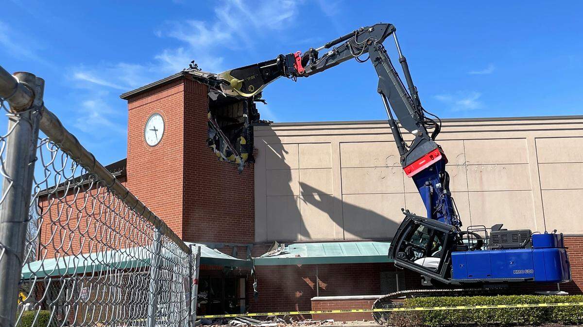 An excavator tears into the clock tower that for many years stood at the corner of the A Southern Season store at University Place mall on Estes Drive in Chapel Hill. It will take about two months to demolish the eastern end of the mall, Ram Realty officials said.