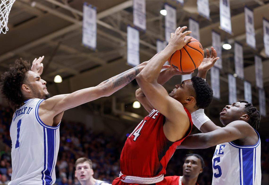 North Carolina State’s Casey Morsell shoots under pressure from Duke’s Dereck Lively II and Mark Mitchell during the first half of Duke’s final regular-season home game against N.C. State on Tuesday, Feb. 28, 2023, at Cameron Indoor Stadium in Durham, N.C.