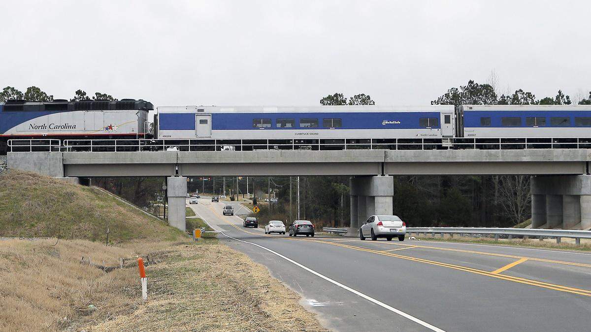 A train goes over a railroad bridge over Hopson Road in Research Triangle Park in this file photo from February 2016. The old tracks were at road level. The N.C. Department of Transportation plans to eliminate several railroad crossings in North Raleigh as well, including those at Durant and New Hope Church roads starting later this year.