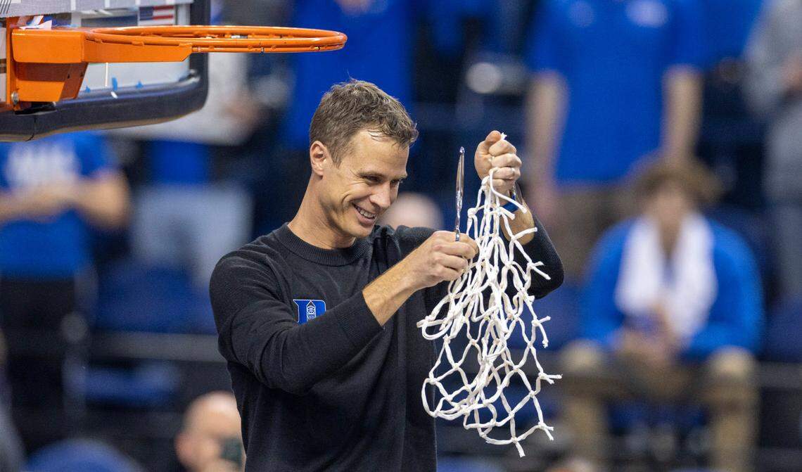 Duke coach Jon Scheyer celebrates by cutting down the net after leading the Blue Devils to an ACC Tournament Championship with a 59-49 victory over Virginia on Saturday, March 11, 2023 at the Greensboro Coliseum in Greensboro, N.C.