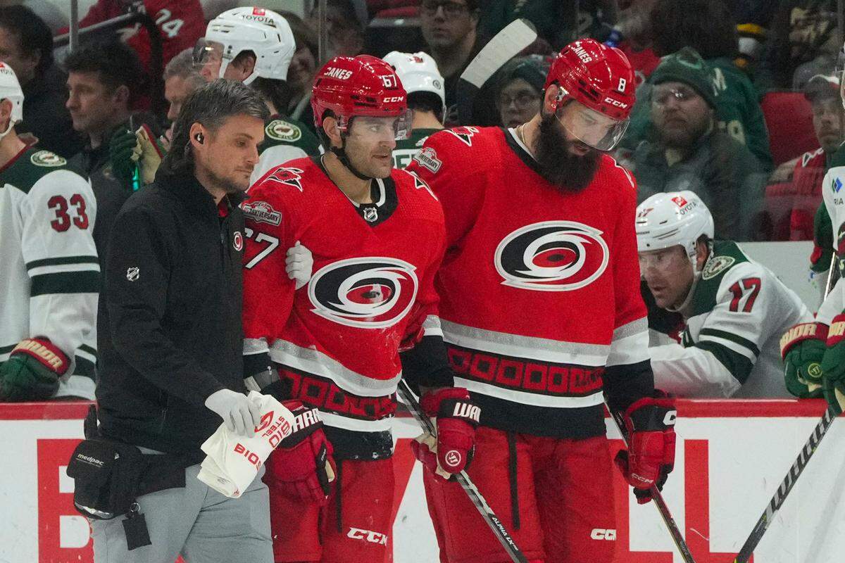 Jan 19, 2023; Raleigh, North Carolina, USA; Carolina Hurricanes left wing Max Pacioretty (67) is helped off the ice by defenseman Brent Burns (8) and a trainer after being injured in the third period against the Minnesota Wild at PNC Arena. Mandatory Credit: James Guillory-USA TODAY Sports