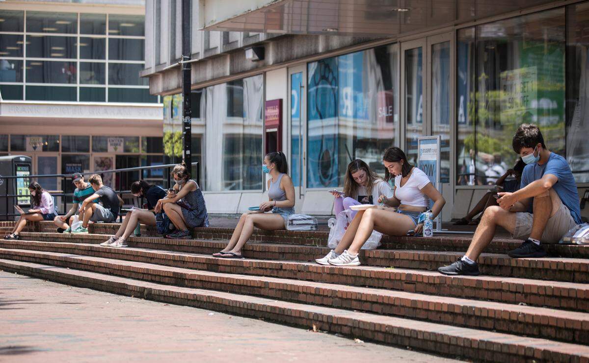 Students maintain physical distance as they line the perimeter of “The Pit” on UNC-Chapel Hill’s campus during breaks between classes on Monday, Aug. 10, 2020, the first day of the fall semester.