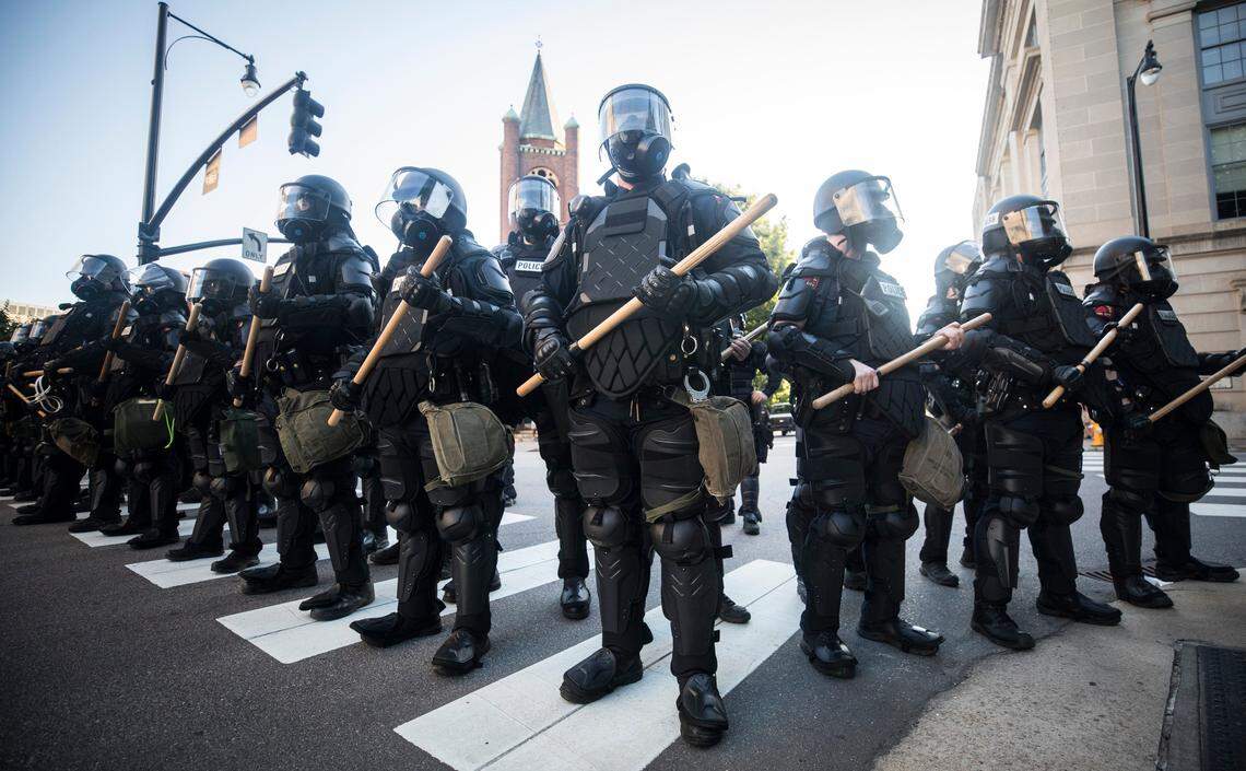 Raleigh police officers in riot gear stand at the intersection of Salisbury and Morgan Streets downtown after tear gassing peaceful protesters demonstrating in the wake of George Floyd’s murder in Minneapolis on Sunday, May 31, 2020.