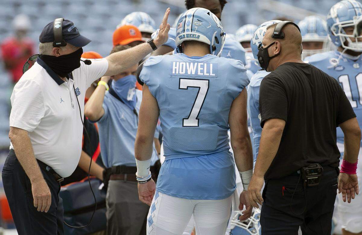 Offensive coordinator Phil Longo, right, and head coach Mack Brown congratulate quarterback Sam Howell after the Tar Heels’ scored to take a commanding 24-6 lead in the fourth quarter against Syracuse at Kenan Stadium on Saturday, September 12, 2020 in Chapel Hill, N.C.