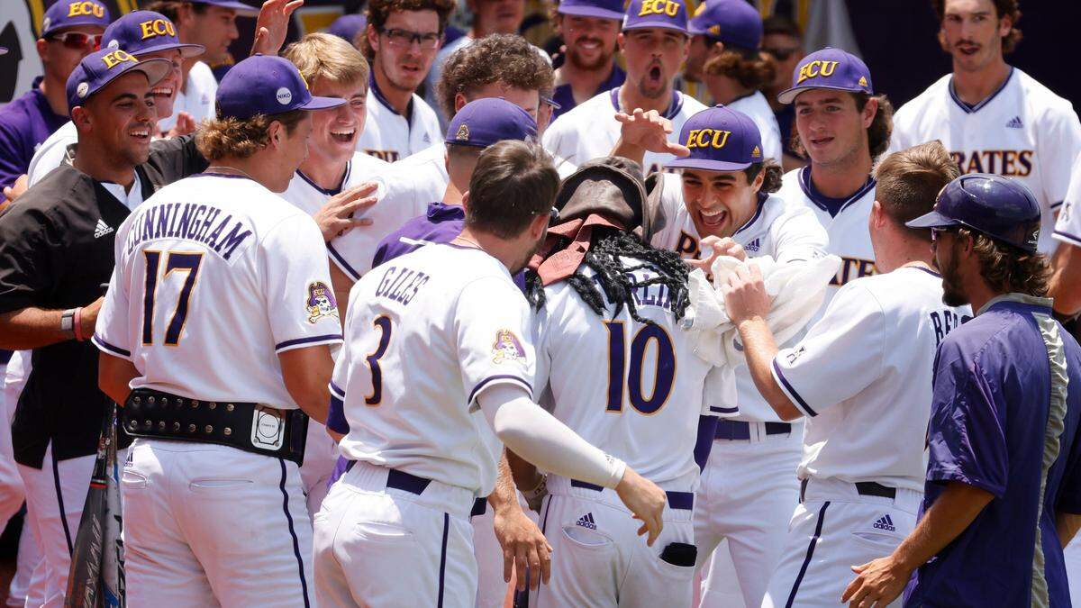 The team surrounds East Carolina’s Jacob Starling (10) after he hit a two-run homerun during ECUís game against Texas in the Greenville Super Regional at Clark-LeClair Stadium Friday, June 10, 2022.