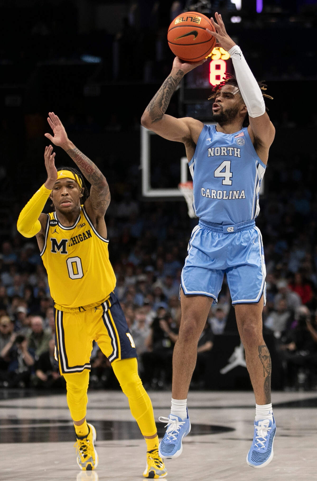 North Carolina’s R.J. Davis (4) shoots over Michigan’s Dug McDaniel (0) during the second half on Wednesday, December 21, 2022 at the Spectrum Center in Charlotte, N.C.