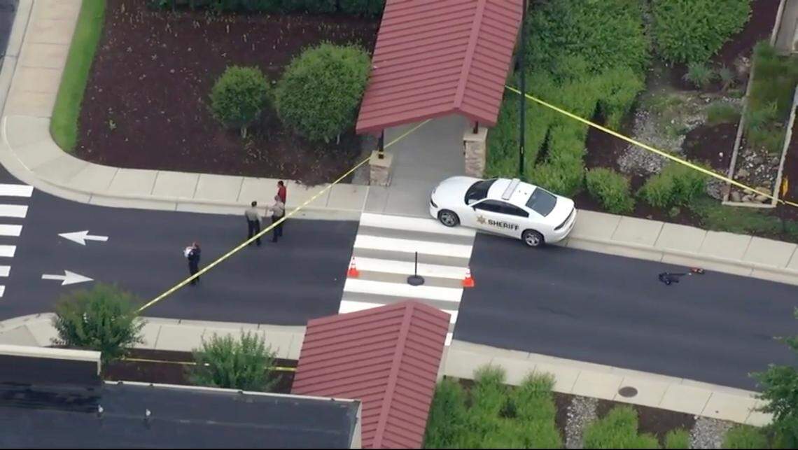 Law enforcement officers stand outside of yellow tape marking the scene where there was a report of shots fired at UNC Health in Clayton, Monday, June 10, 2024.