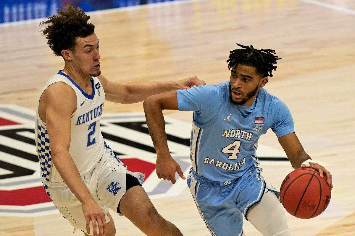 North Carolina’s R.J. Davis (4) drives past Kentucky’s Devin Askew (2) in the first half of an NCAA college basketball game, Saturday, Dec. 19, 2020, in Cleveland.