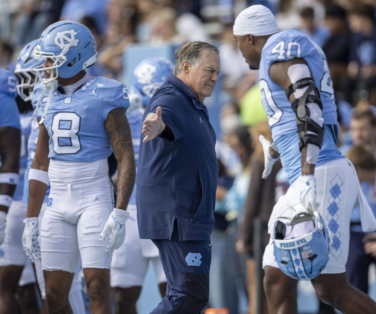 North Carolina coach Bill Belichick greets linebacker Tyler Thompson (40) during the pre-game warm up prior to the Tar Heels’ game against Virginia on Saturday, October 25, 2025 at Kenan Stadium in Chapel Hill, N.C. 