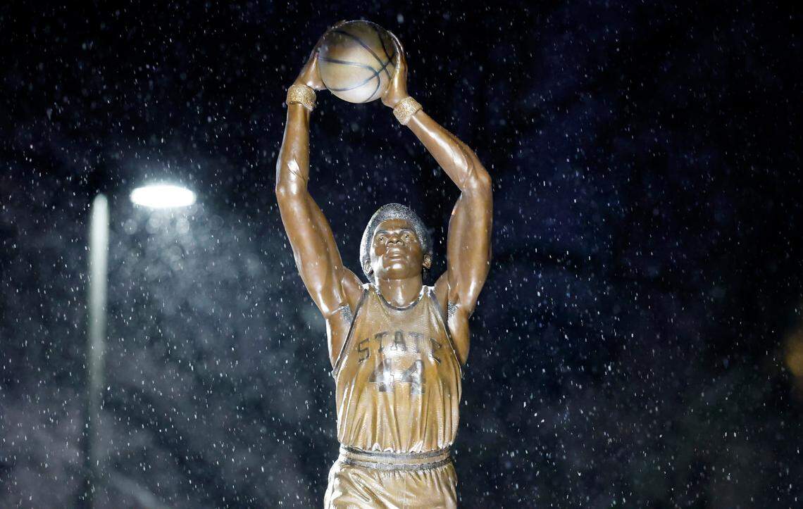 Snow falls around the statue of N.C. State great David Thompson outside Reynolds Coliseum in Raleigh, N.C., Friday, Jan. 10, 2025.
