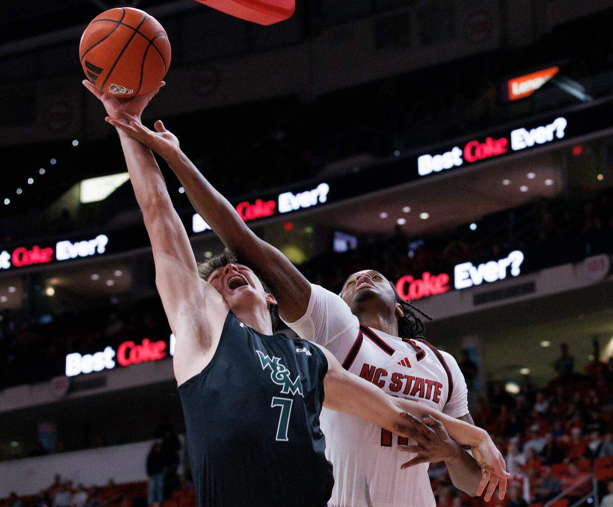 William & Mary’s Kyle Frazier and N.C. State’s Dennis Parker Jr. battle for a rebound during the first half of the Wolfpack’s game at Lenovo Center on Friday, Nov. 22, 2024, in Raleigh, N.C.