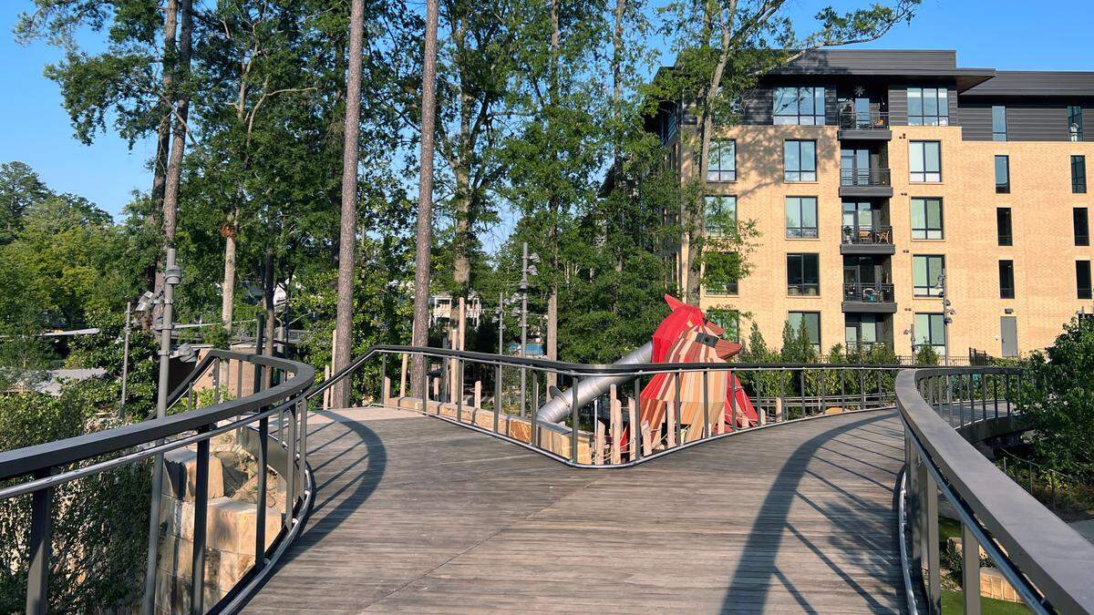 The walkway leading to The Nest, the children’s play area, at Downtown Cary Park sits over a splash pad, slides, and a toddler play area. Two large wooden Cardinals, the state’s bird, sit at the center of The Nest.
