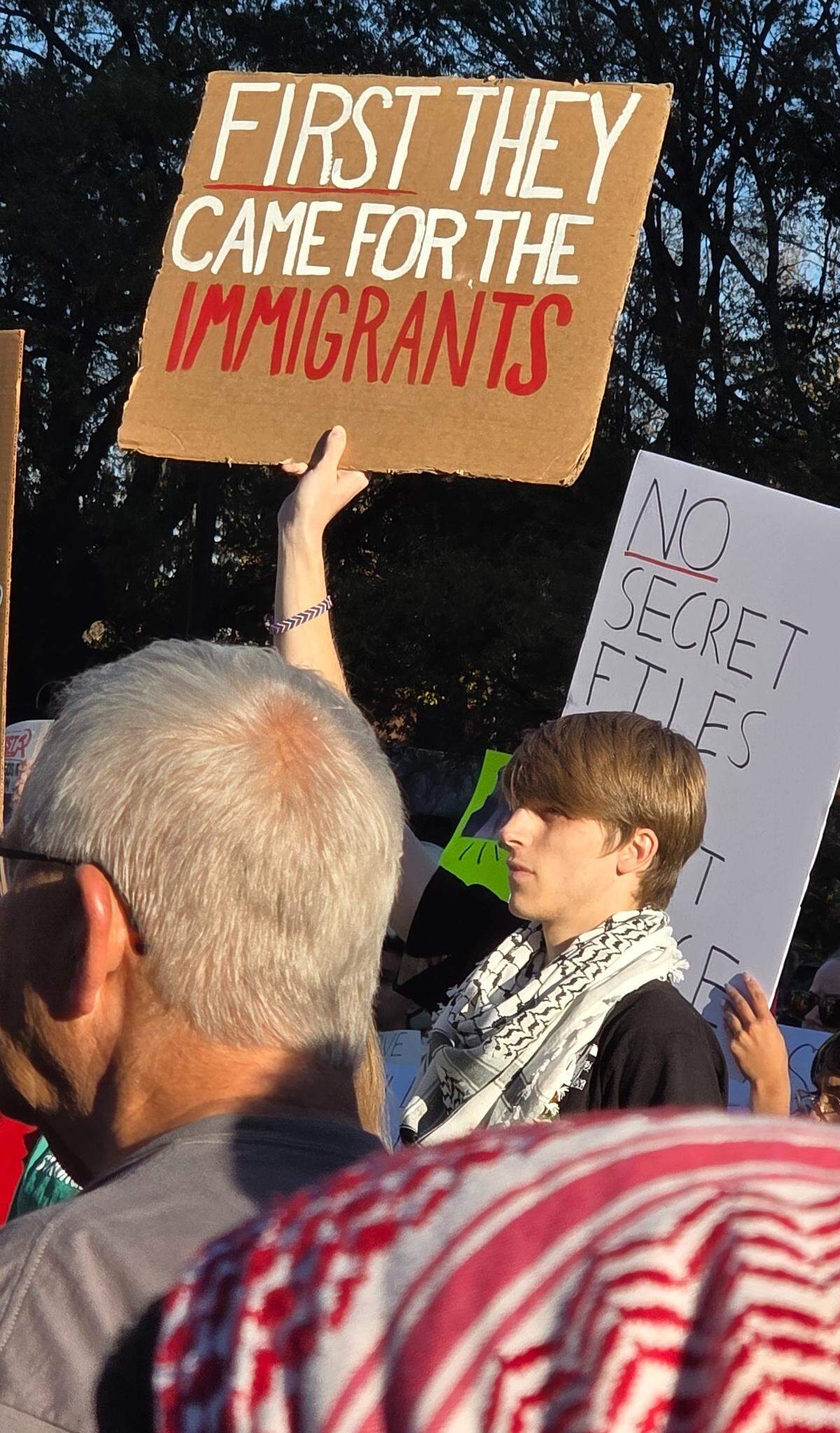 A protester holds a sign during a rally in downtown Raleigh on Sunday denouncing a federal immigration operation underway in North Carolina.