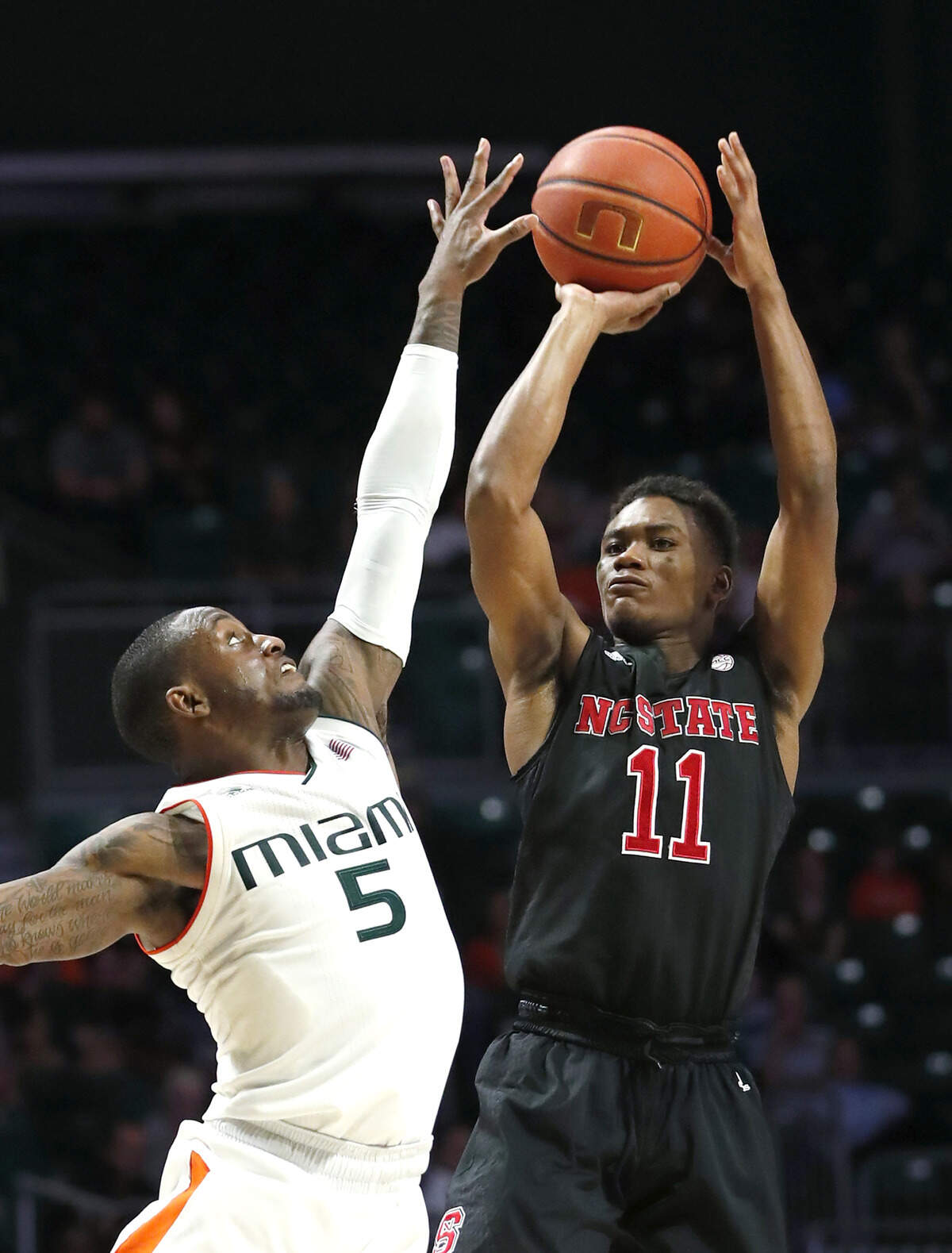 N.C. State guard Markell Johnson (11) takes a shot against Miami guard Zach Johnson (5) during the second half of an NCAA college basketball game, Thursday, Jan. 3, 2019, in Coral Gables, Fla.
