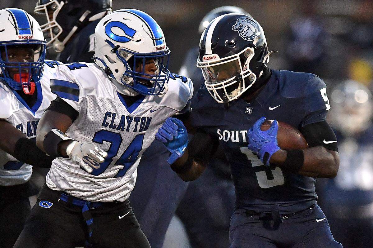 Southeast Raleigh running back Christian Freeman (5) runs for yardage against Clayton linebacker Imari Givens (34) during the first half. The Southeast Raleigh Bulldogs and the Clayton Comets met in a non-conference football game in Raleigh, N.C. October 3, 2025