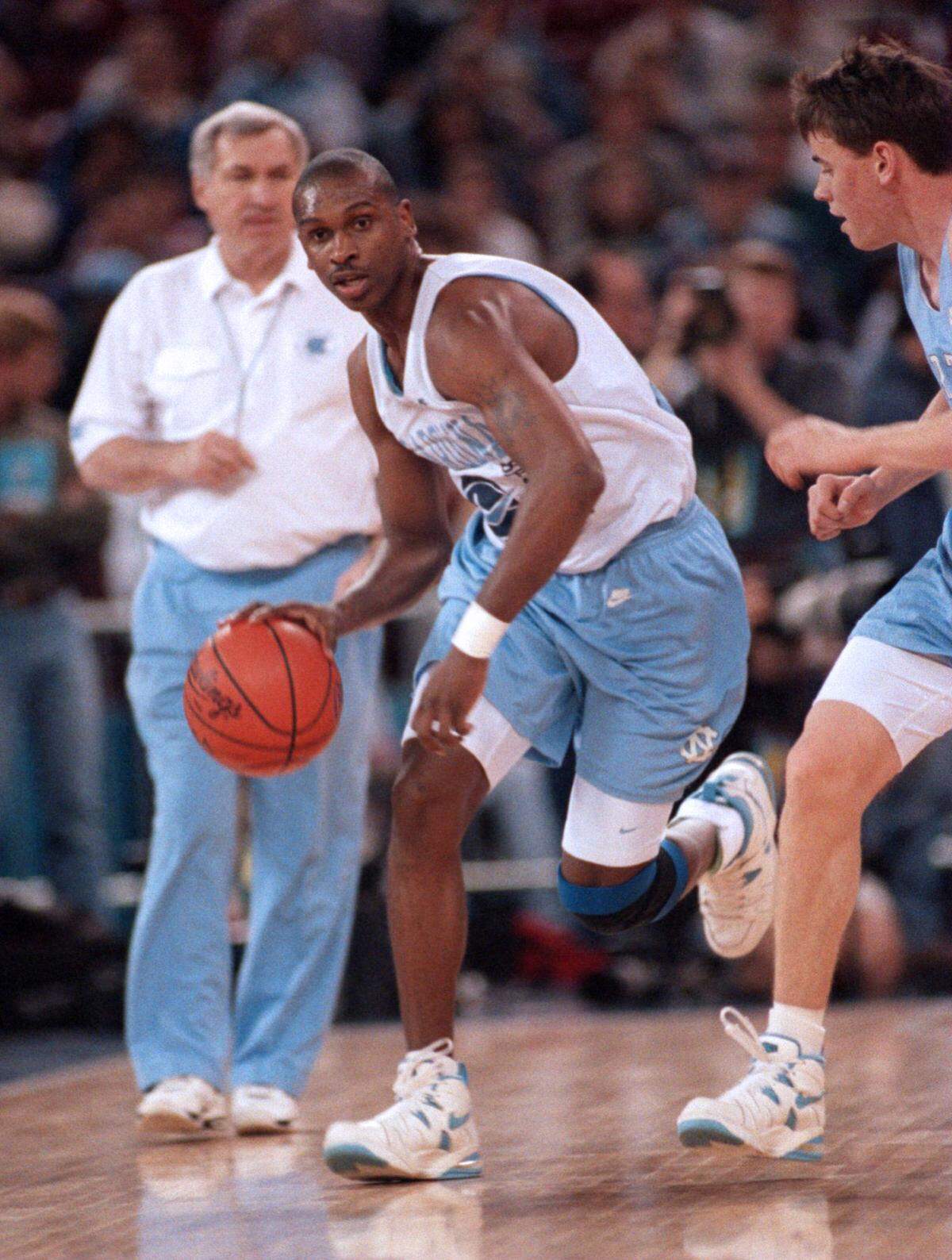 UNC’s Donald Williams brings the ball up court during practice in the Kingdome as coach Dean Smith looks on in 1995.
