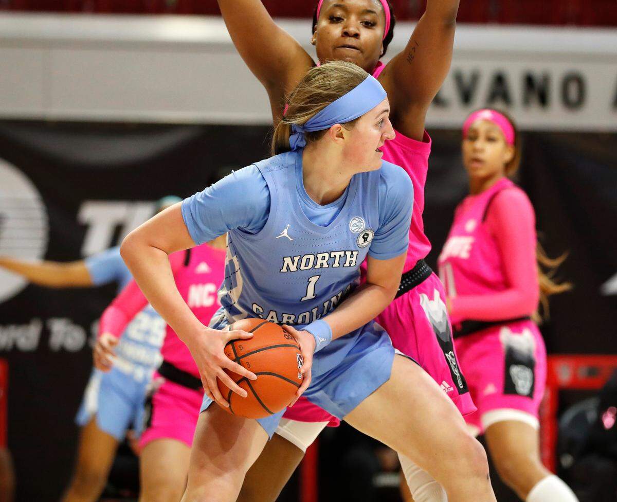 North Carolina’s Alyssa Ustby (1) looks to get out of the pressure applied by N.C. State’s Kayla Jones (25) during the first half of N.C. State’s game against UNC in the annual Play4Kay game at Reynolds Coliseum in Raleigh, N.C., Sunday, February 21, 2021.