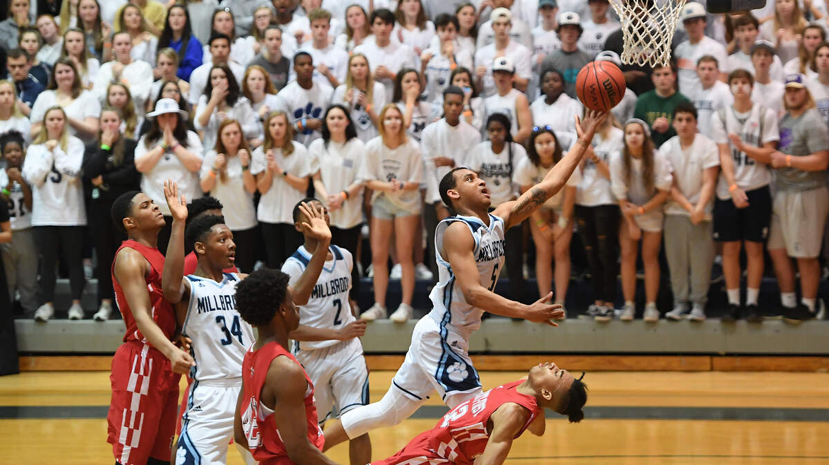 Phillip Burwell (5) of Millbrook scores with a layup against Trevon Bell (12) of Seventy-First. The Seventy-First Falcons visited the Millbrook Wildcats in a high school men basketball game on March 5, 2019.