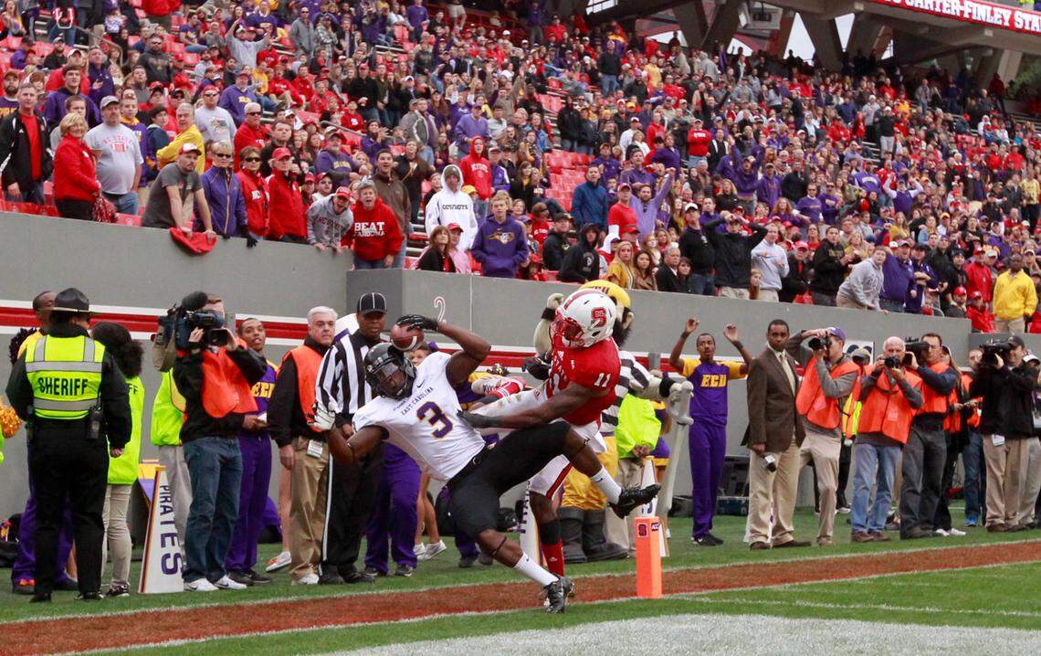 East Carolina wide receiver Lance Ray (3) pulls in a 25-yard touchdown pass as N.C. State cornerback Juston Burris (11) defends during ECU’s 42-28 victory over the Wolfpack at Carter-Finley Stadium in 2013.