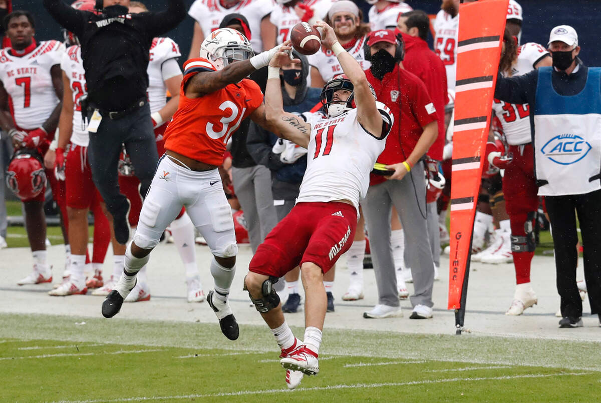 N.C. State linebacker Payton Wilson (11) can’t pull in the interception intended for Virginia’s Shane Simpson (31) during the first half of N.C. State’s game against Virginia at Scott Stadium in Charlottesville, Va., Saturday, Oct. 10, 2020.