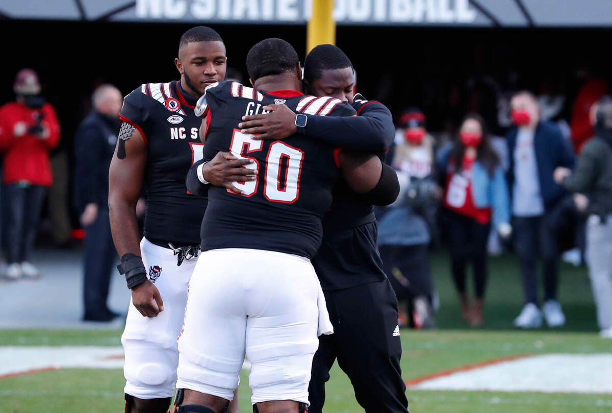 N.C. State linebacker Louis Acceus hugs center Grant Gibson (50) after Acceus was acknowledged on senior day before N.C. State’s game against Georgia Tech at Carter-Finley Stadium in Raleigh, N.C., Saturday, Dec. 5, 2020.