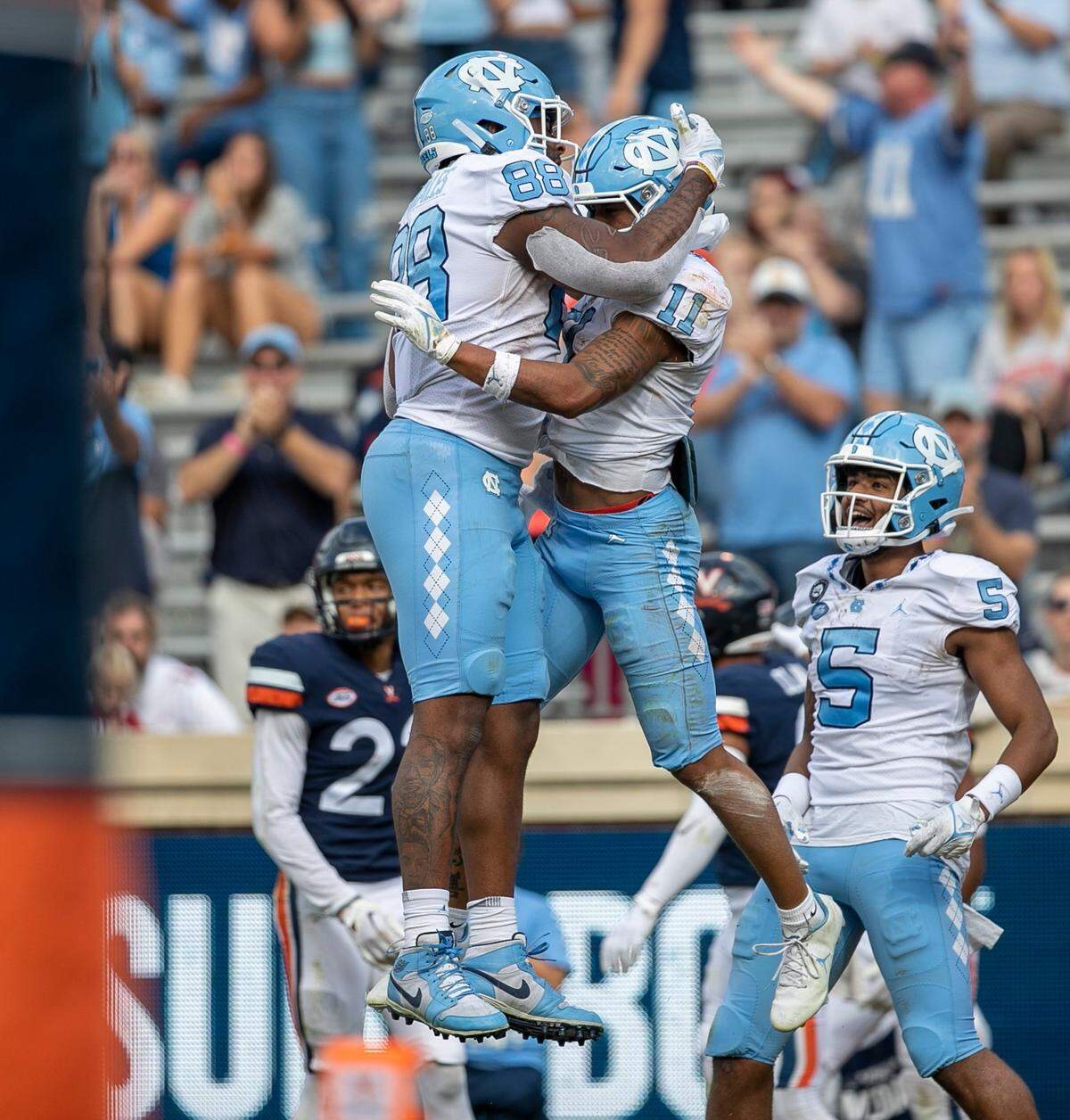 North Carolina’s Josh Downs (11) celebrates with teammate Kamari Morales (88) after scoring on a 19-yard pass reception from quarterback Drake Maye in the third quarter to give the Tar Heels’ a 24-21 lead on Saturday, November 5, 2022 at Scott Stadium in Charlottesville, Va.