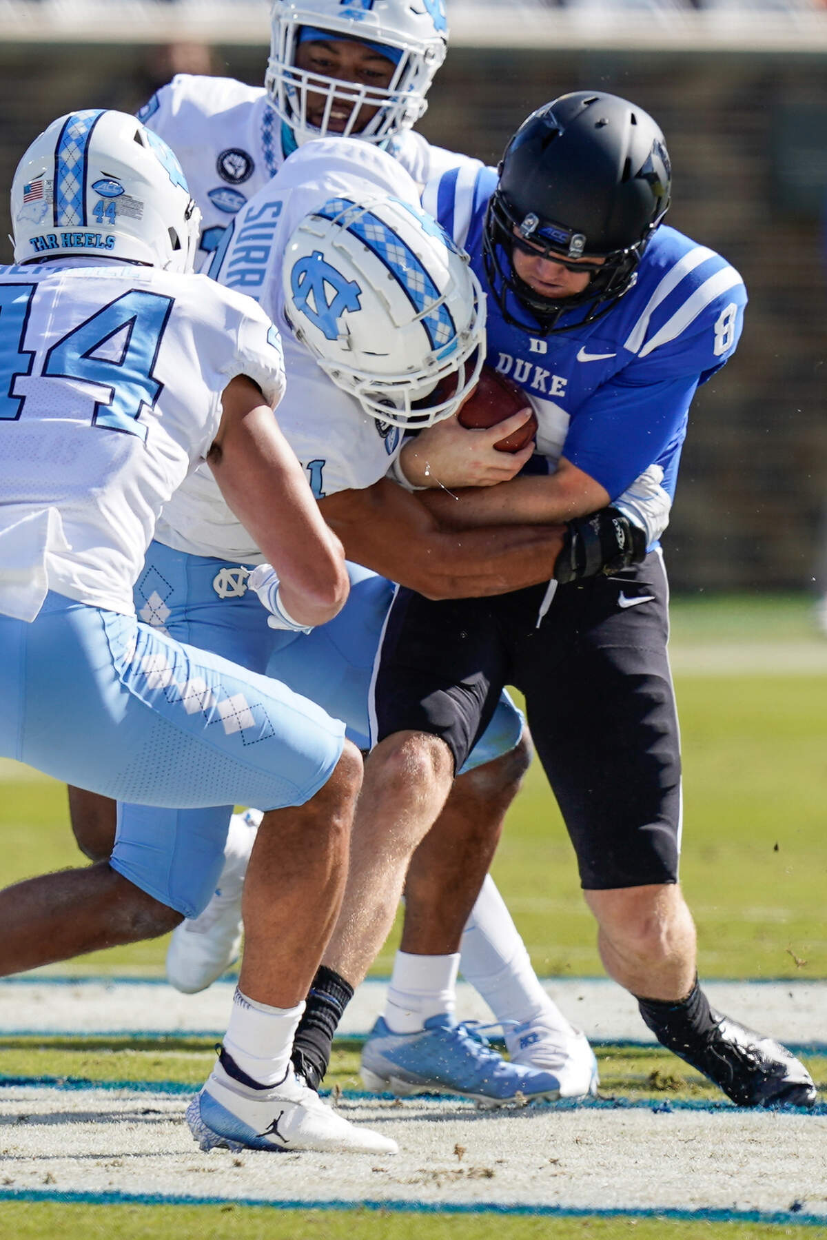 Duke Blue Devils quarterback Chase Brice (8) is tackled by North Carolina Tar Heels linebacker Chazz Surratt (21) during the first quarter at Wallace Wade Stadium. 