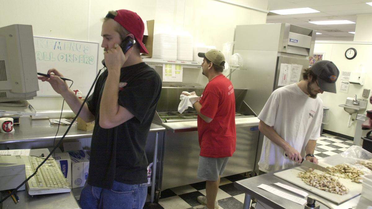 The popular carry-out pizza shop Capital Creations will close next month after more than 30 years in Raleigh. Pictured are Capital Creations employees working a busy Friday lunch shift in 2003.