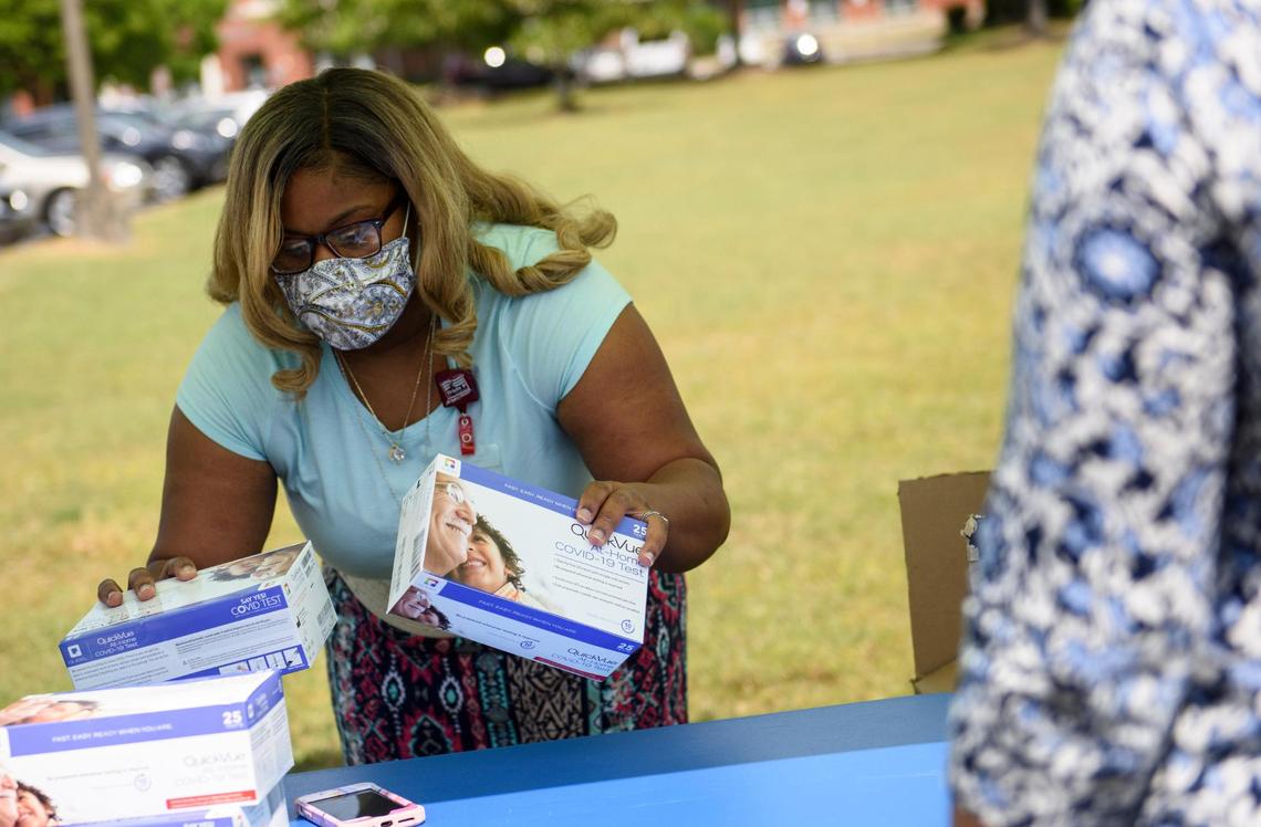 A Pitt County Health Department worker passes out home test kits in Greenville, N.C.